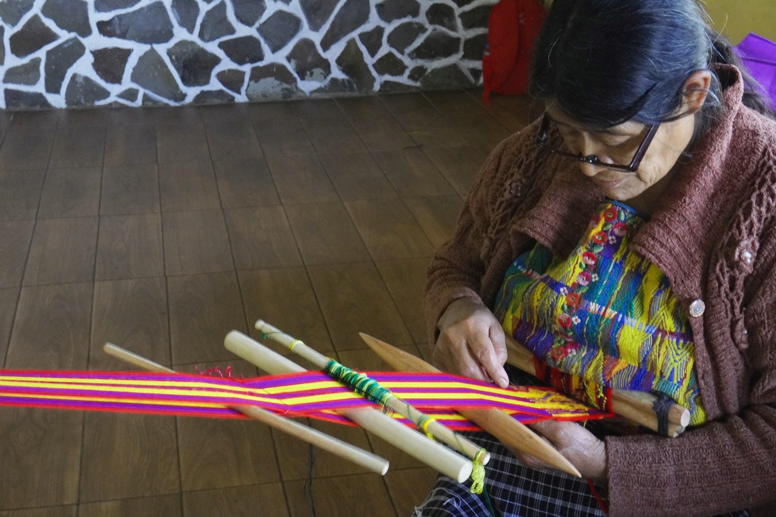  Mujer Kaqchikel realizando un tejido en telar de cintura. Fotografía: cortesía AMIGS 